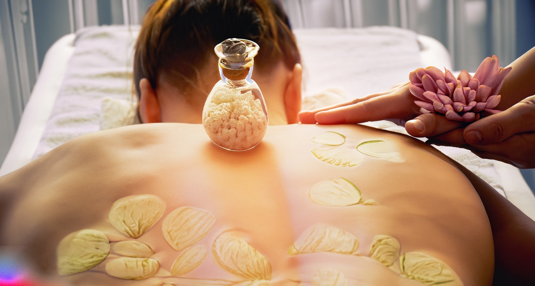 Massageliege mit Patient und Blüte